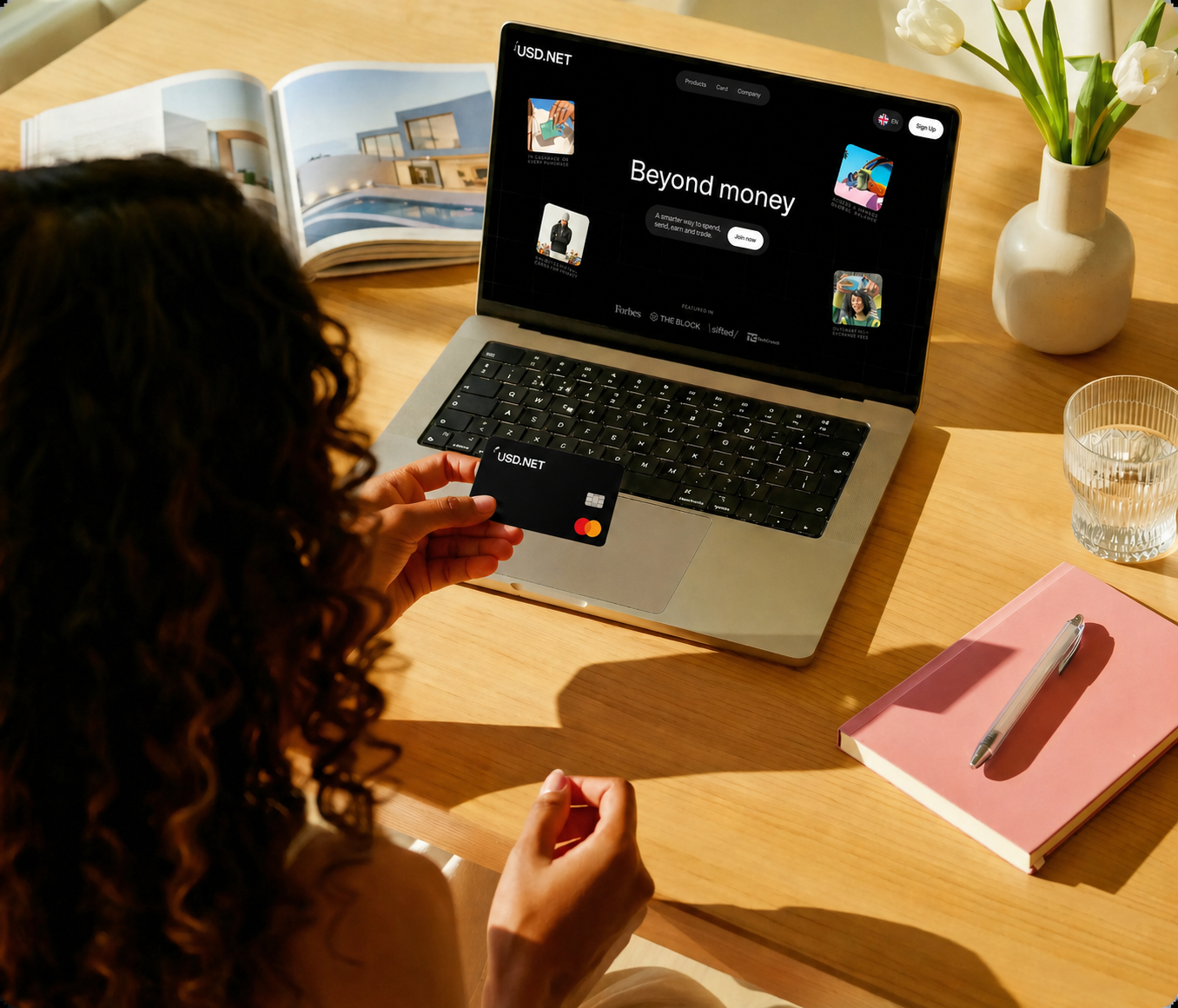 Person holding a USD.NET card in front of a laptop